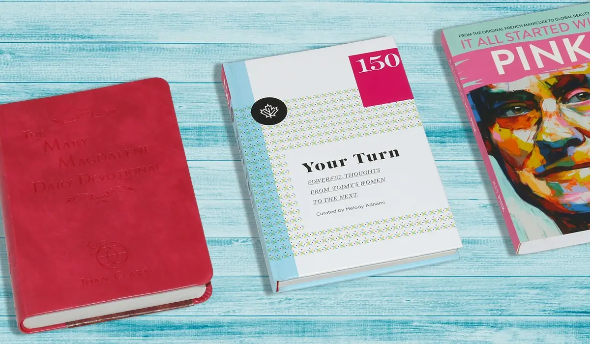 A slim paperback resting beside a thick hardcover novel on a wooden desk, illustrating novella vs novel length